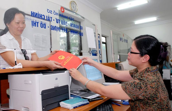 Trao Giấy chứng nhận quyền sử dụng đất tại bộ phận một cửa quận Ba Đình.      Ảnh: Tâm Ánh